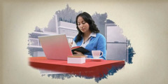 En kvinna sitter med en bibel och en laptop och studerar.