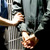 Ein Gefangener wird in Handschellen ins Gefängnis gebracht