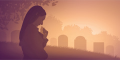 A woman grieves at a cemetery