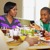 Egy fiú SMS-ezik a családi étkezés közben