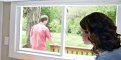 Une femme soucieuse regarde son mari malade par la fenêtre