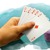 Ein Spieler mit einem Kartenblatt auf der Hand, vor sich Pokerchips