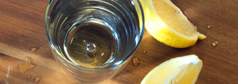 A glass of clean water and pieces of lemon