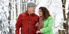 Ein glückliches Ehepaar macht einen Spaziergang in einer Schneelandschaft