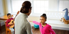 Egy kislány kiabál az anyukájával és a testvérére mutat