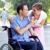 A man in a wheelchair gives his wife a flower