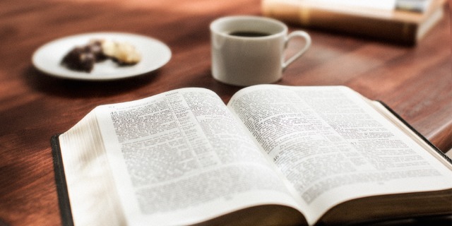 Una Biblia abierta y una taza de café