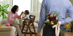A man prepares to surprise his wife with a bouquet of flowers