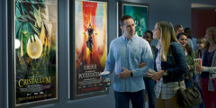 Dvojice si prohlíží filmové plakáty, na kterých jsou postavy s nadpřirozenými schopnostmi