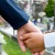 Дете и родител се држат за рака на гробишта