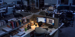 En man sitter på ett kontor sent på kvällen och jobbar över.