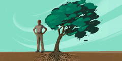 Ein junger Mann steht aufrecht neben einem Baum, der sich im Wind biegt