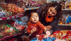 Ein kleiner Junge will sich im Laden Süßigkeiten nehmen, aber die Mutter sagt Nein