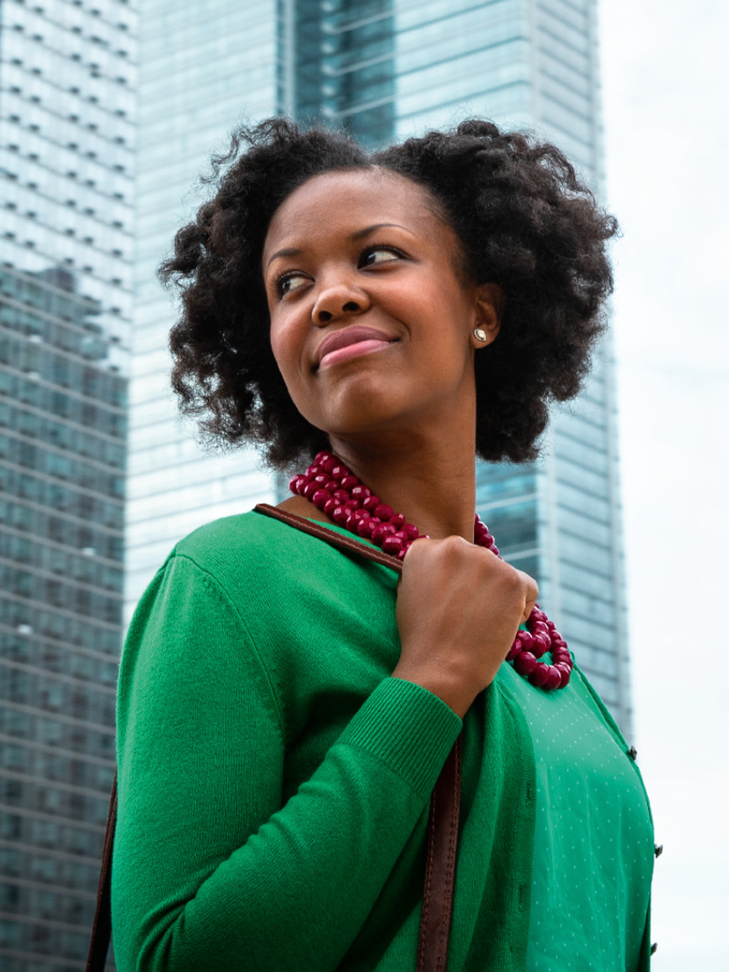 A happy and confident woman walking in a big city.