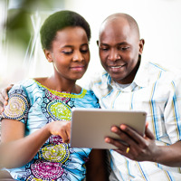 Um marido e sua esposa lendo um artigo no tablet.