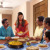 Una familia invita a otros a cenar en su casa.