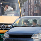 An angry bus driver yelling at another driver who has cut him off in traffic.