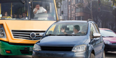 An angry bus driver yelling at another driver who has cut him off in traffic.