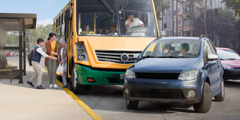 Um motorista de ônibus bastante irritado com outro motorista que o fechou no trânsito. Enquanto isso, uma mãe e seu filho ajudam uma senhora idosa a descer do ônibus.