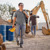 A man smiles as he leaves a construction site after his work shift.