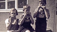 Elisabeth, Paul-Gerhard und Hans-Werner Kusserow spielen als Kinder auf ihren Mundharmonikas.