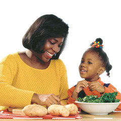 A mother and her little girl prepare food together