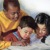 Un niño le lee de la Biblia a dos niños más pequeños