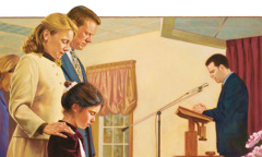 A family listens as a prayer is said at a meeting