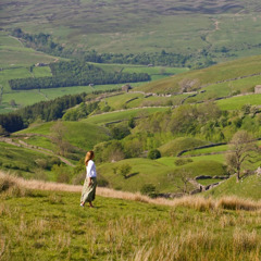 Una mujer caminando sobre un tranquilo campo verde