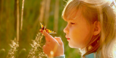 دختری به یک پروانه نگاه می‌کند