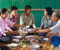 Un matrimonio mayor comiendo con sus hijos adultos