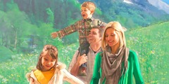 Una famiglia con due bambini cammina felice in una zona di montagna