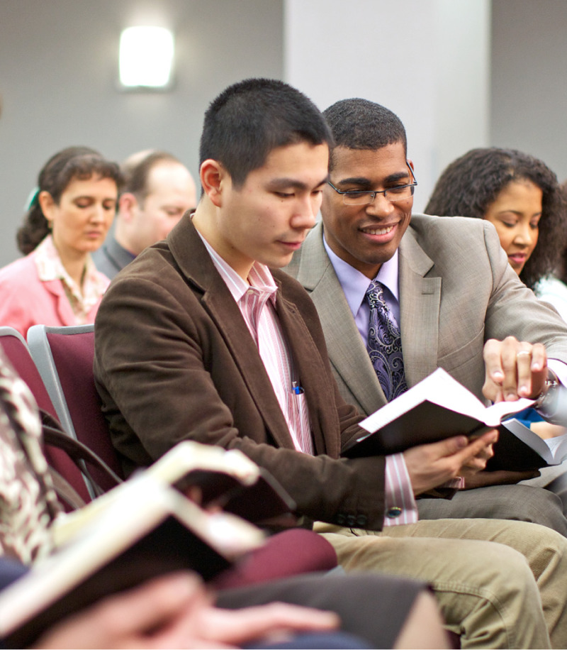 Pessoas lendo a Bíblia numa reunião