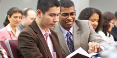 Pessoas a lerem a Bíblia numa reunião cristã