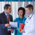 A Hospital Liaison Committee representative providing two clinicians with the “Clinical Strategies to Avoid Blood Transfusion” information packet at a hospital.