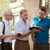 Two of Jehovah’s Witnesses in the house-to-house ministry share a scripture with a man