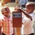 Two young boys putting money into a contribution box