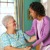 Ein Ehepaar hilft einer kranken älteren Glaubensschwester