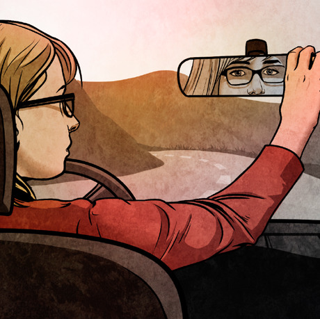 Una joven mira por el espejo retrovisor de su automóvil mientras va conduciendo