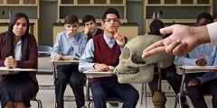 Junge Leute sehen sich in einem Klassenzimmer einen Schädel an