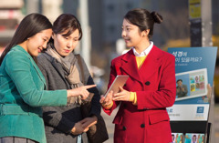 A neatly dressed sister shows a video at a public witnessing cart