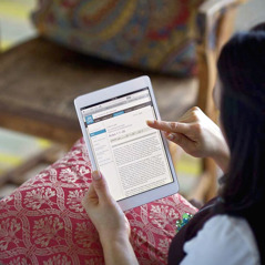 Een vrouw gebruikt haar tablet om op jw.org de online Bijbel te lezen