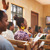 En una reunión de los testigos de Jehová, un hermano hace una pregunta y varios asistentes levantan la mano para comentar.