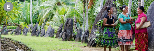 E. Dvě svědkyně Jehovovy mluví se ženou před obřími kamennými kotouči na ostrově Yap