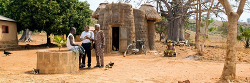 C. Dva svědkové Jehovovi mluví s mužem v jedné vesnici v Beninu