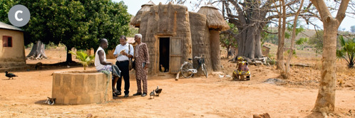 C. Abajulirwa ba Yakuwa babiri nga babuulira omusajja mu kyalo ekimu mu Benin.