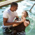 Žena se úplným ponořením pod vodu dává pokřtít jako svědek Jehovův