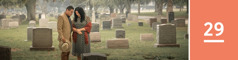 Lesson 29. A couple prays in front of a headstone in a cemetery.