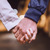 En mann og en kvinne holder hverandre i hånden.