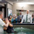 Een Bijbelstudent kijkt toe terwijl een andere man op een grote bijeenkomst gedoopt wordt, en hij overweegt om zich ook te laten dopen.